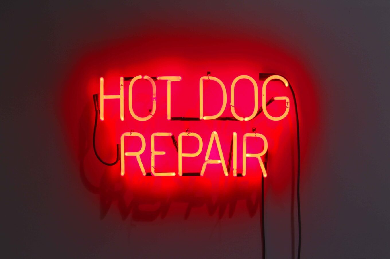 Neon sign spelling out 'HOT DOG REPAIR'